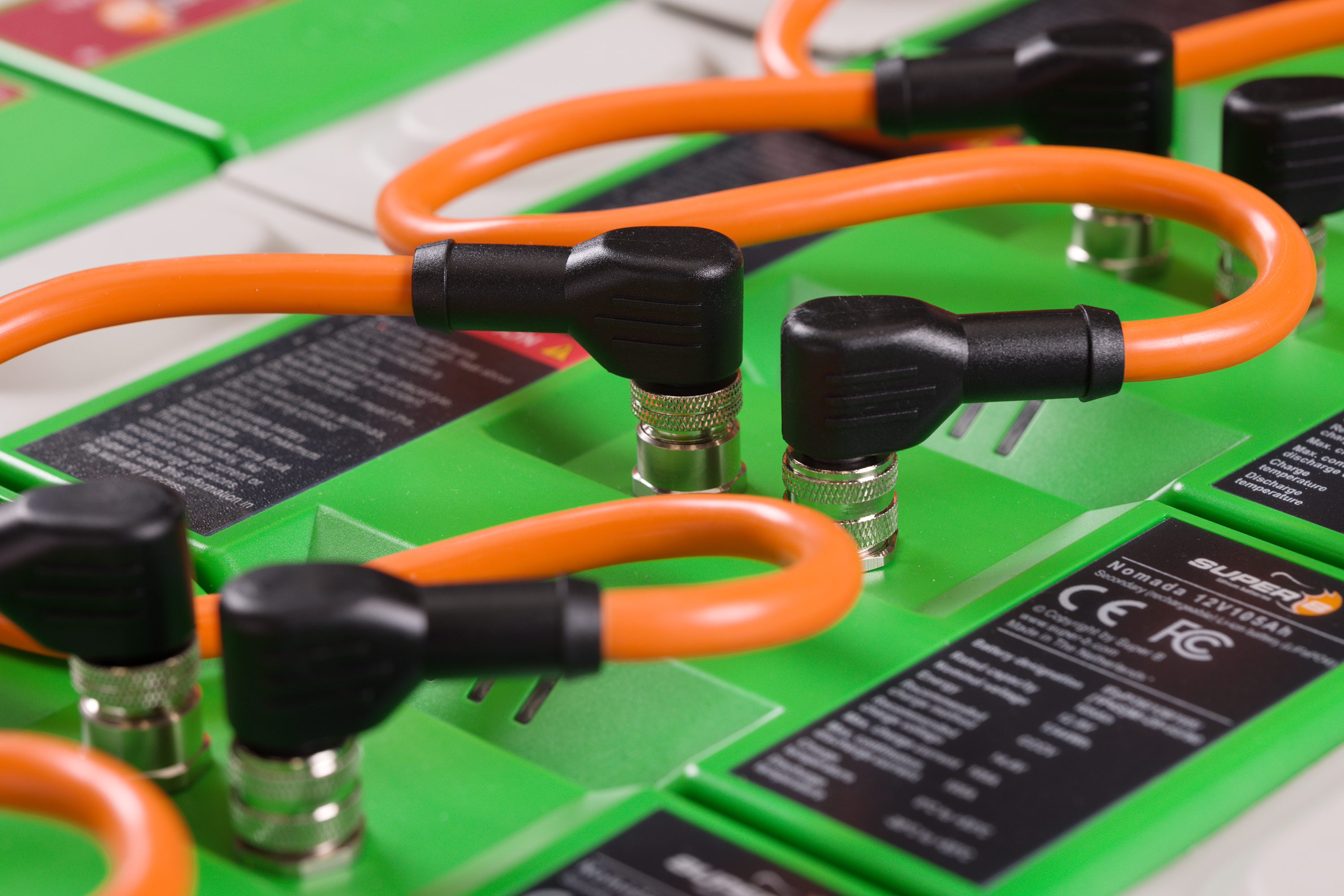 detailopname van technische installatie met oranje kabels aangesloten op groene super b lithium accu's
