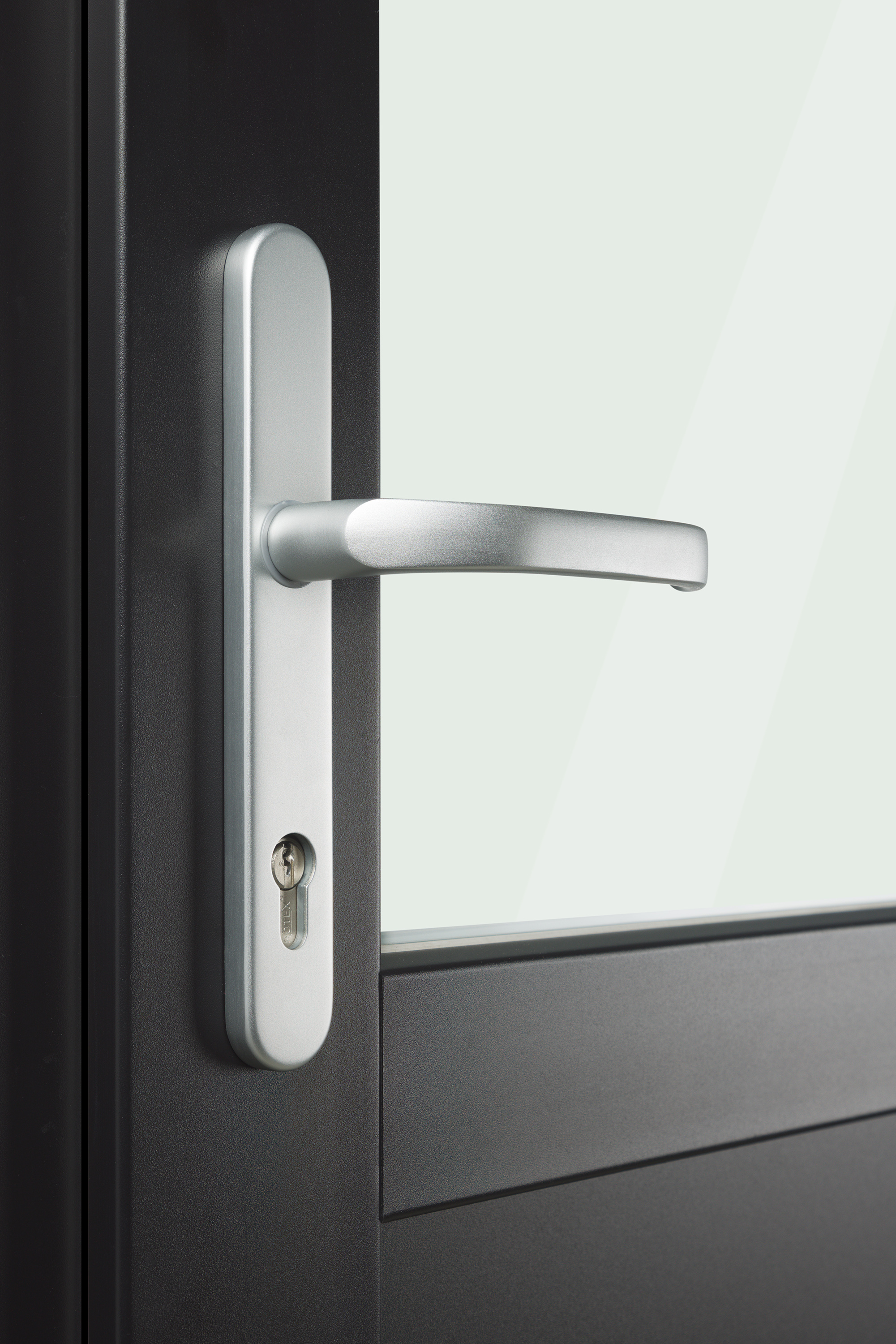 detailopname van een modern zilverkleurig deurbeslag op een antracietgrijze deur met glas